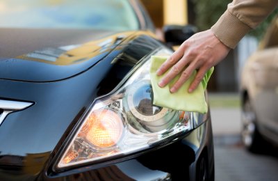 Hand with duster cleaning headlights